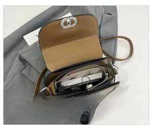Detail of the brown saddle bag showing interior compartments and metal twist lock