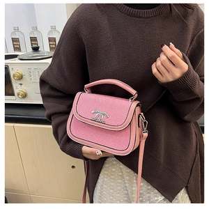 Détail du sac selle rose avec tissu texturé, garniture en cuir et boucle argentée