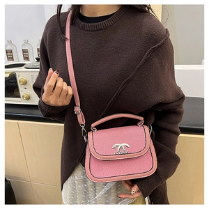 Détail du sac selle rose texturé avec fermoir argenté et logo de marque distinctif
