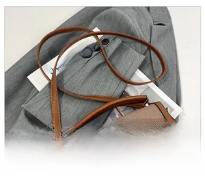 Détails du sac de selle en cuir marron et tissu tissé avec fermoir métallique