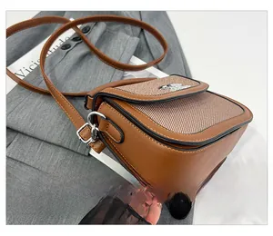 Gros plan détaillé montrant les coutures de précision du sac besace marron