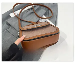 Détail du sac selle vintage avec fond renforcé et cuir texturé bicolore élégant