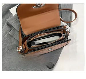 Détail montrant les compartiments internes et l'espace de rangement du sac selle tissé marron