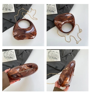 Amber marble acrylic clutch with gold chain strap and integrated oval handle detail