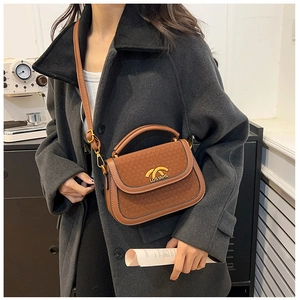 Brown leather saddle bag with gold metal hardware and adjustable strap on a female model