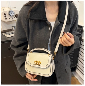 Detail showing cream saddle bag with gold interlocking logo and textured leather finish