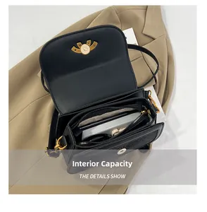 Interior view of black faux leather saddle bag showing compartments and gold hardware