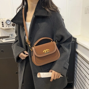 Brown retro leather saddle bag with gold metal clasp and embossed brand texture