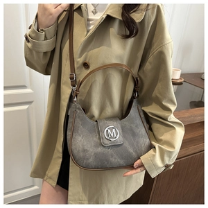 Close-up of vintage grey moon bag showing matte texture and silver M logo detail