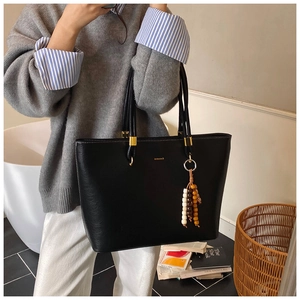 Sac fourre-tout noir en cuir avec détails dorés et breloque en perles colorées