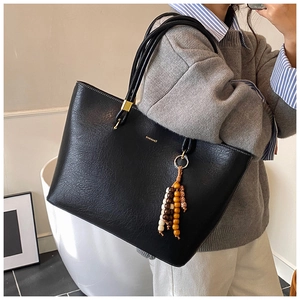Détail du grand cabas en cuir noir avec texture grainée et pendentif perles boho