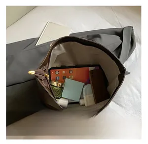 Vue de dessus de l'intérieur spacieux d'un cabas en cuir marron avec tablette et cosmétiques