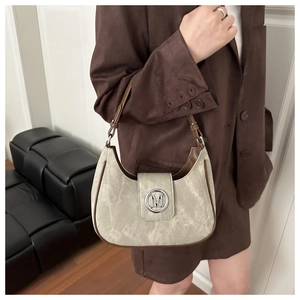 Detailed side view of a half-moon shoulder bag with matte texture and silver M logo