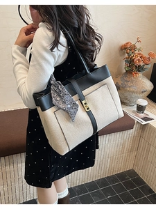 Detail of canvas tote bag with color blocking and silk scarf on model in a cafe