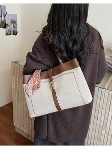 Detail of canvas tote bag with brown leather trim and decorative paisley silk scarf handle