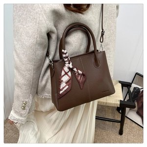 Detail of dark brown pebble leather tote bag with silk scarf and detachable shoulder strap