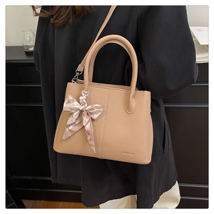 Close-up of apricot lychee pattern leather tote bag with printed silk scarf detail