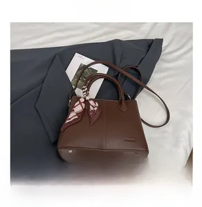 Detail of dark brown pebble leather tote bag with silk scarf and adjustable strap