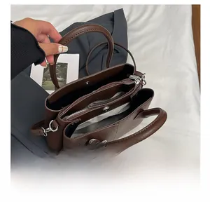 Top view of dark brown leather bucket bag showing three-compartment interior and silk scarf