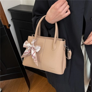 Large beige leather tote bag with decorative silk scarf and adjustable crossbody strap