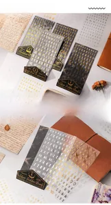 Macro shot of gold foil vintage letter stickers on retro PET paper for scrapbooking deco