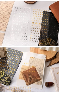 Macro detail of gold and silver foil alphabet stickers on vintage letters and journals