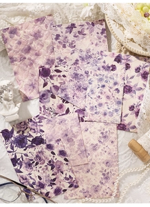 Dettaglio di carta scrapbooking vintage con motivi floreali viola e texture goffrata