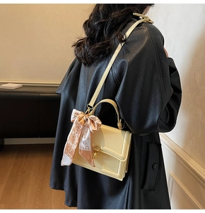 Detail of cream leather handbag with heart print scarf handle and gold twist lock