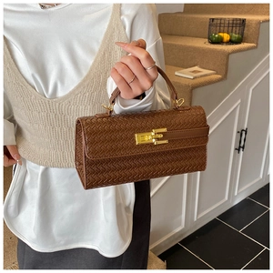 Close-up of dark brown woven leather handbag with elegant gold metal hardware lock detail