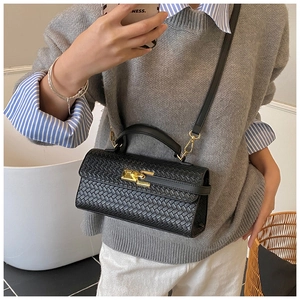 Detail of black woven crossbody bag with gold twist lock and textured leather finish