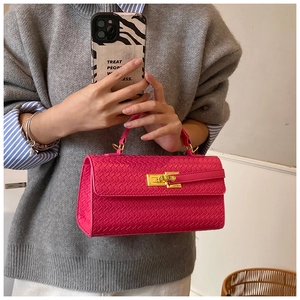 Close-up of hot pink woven texture handbag with golden twist lock and top handle detail