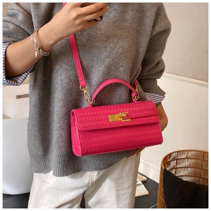Detail of rose red woven leather handbag with gold metal lock and shoulder strap