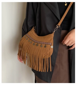 Détail du sac à bandoulière en daim marron avec longues franges et pièces vintage