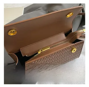 Macro detail of brown woven texture bag showing gold hardware and inner lining