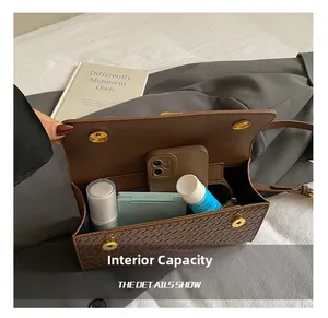 Interior view of brown woven crossbody bag showing capacity for phone and cosmetics