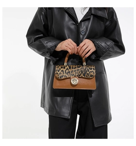 Detail of leopard print flap and gold lock on vintage brown crossbody bag with leather texture