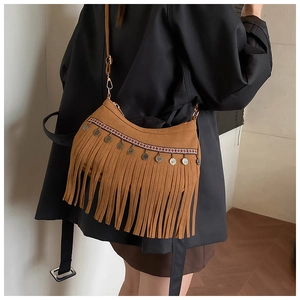 Détail du sac à franges bohème avec bandoulière ethnique et décorations métalliques