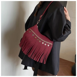 Détail du sac à bandoulière bordeaux à franges avec broderie ethnique et pièces dorées