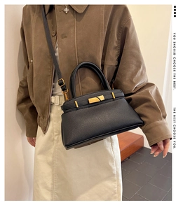 Detailansicht der schwarzen Handtasche aus Leder mit goldener Schließe und Riemen