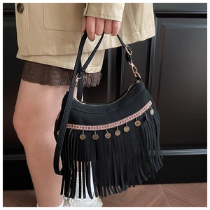 Détail d'un sac à franges bohème avec broderie ethnique et breloques en laiton