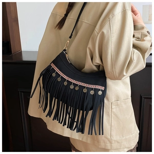 Détail du sac à franges noir bohème avec bandoulières ethniques et charms pièces