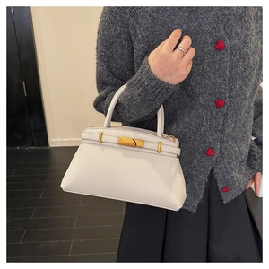 Detailansicht der weißen Lederhandtasche mit Litschi-Muster und Metallverschluss
