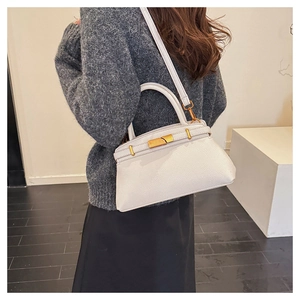 Weiße Lederhandtasche mit goldenem Verschluss am Modell zur Größenansicht gezeigt