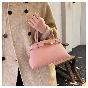 Detail der rosa Handtasche aus Leder mit Litschimuster und goldenem Schlossverschluss