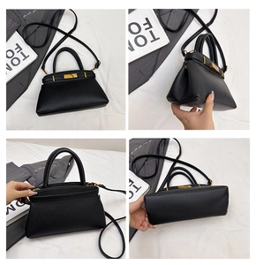 Detailansicht der schwarzen Trapez-Tasche mit Lychee-Muster und goldenem Verschluss