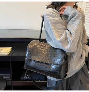 Detailed view of black crocodile pattern leather texture on a stylish underarm bag