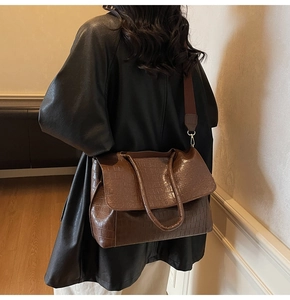 Detailed view of deep brown crocodile pattern tote bag with wide shoulder strap
