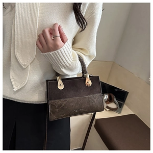 Detail of vintage square bag showing faux suede stitching and gold metal hardware