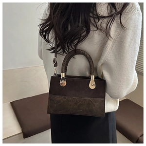 Brown retro patchwork handbag with woven handle worn by model in minimalist room
