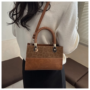 Detailed view of brown leopard print handbag with woven handle and fashion branding